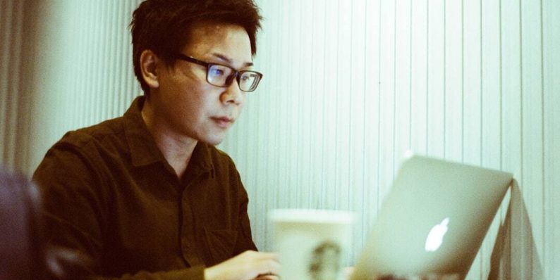 a man sitting at a table using a laptop computer seo agency team, digital marketing strategy, link building tools