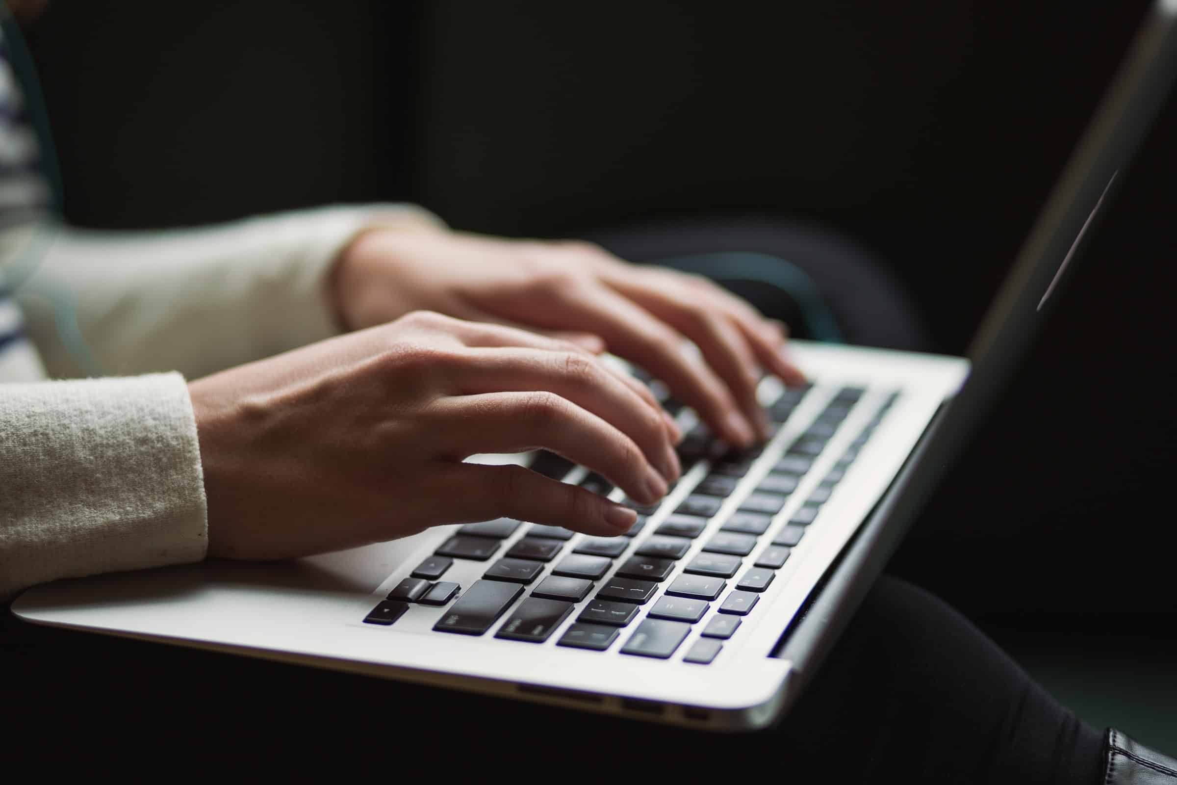 Person writing on laptop