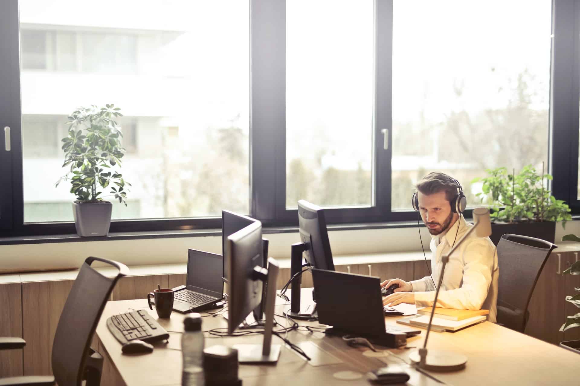 Man with head[hones facing monitor