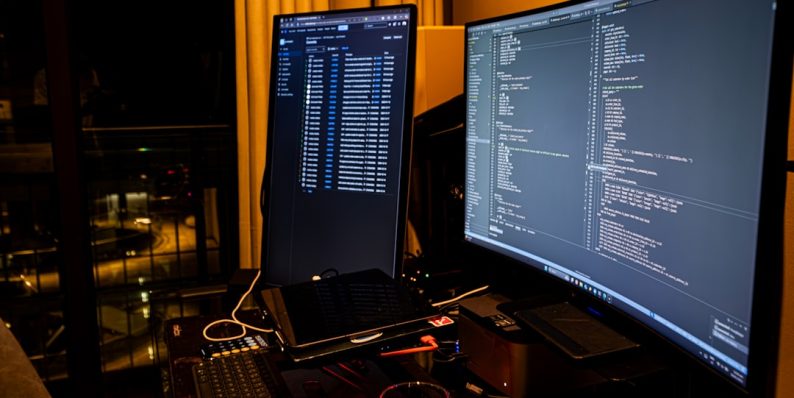 A man sitting in front of a computer monitor windows terminal, dism, command prompt
