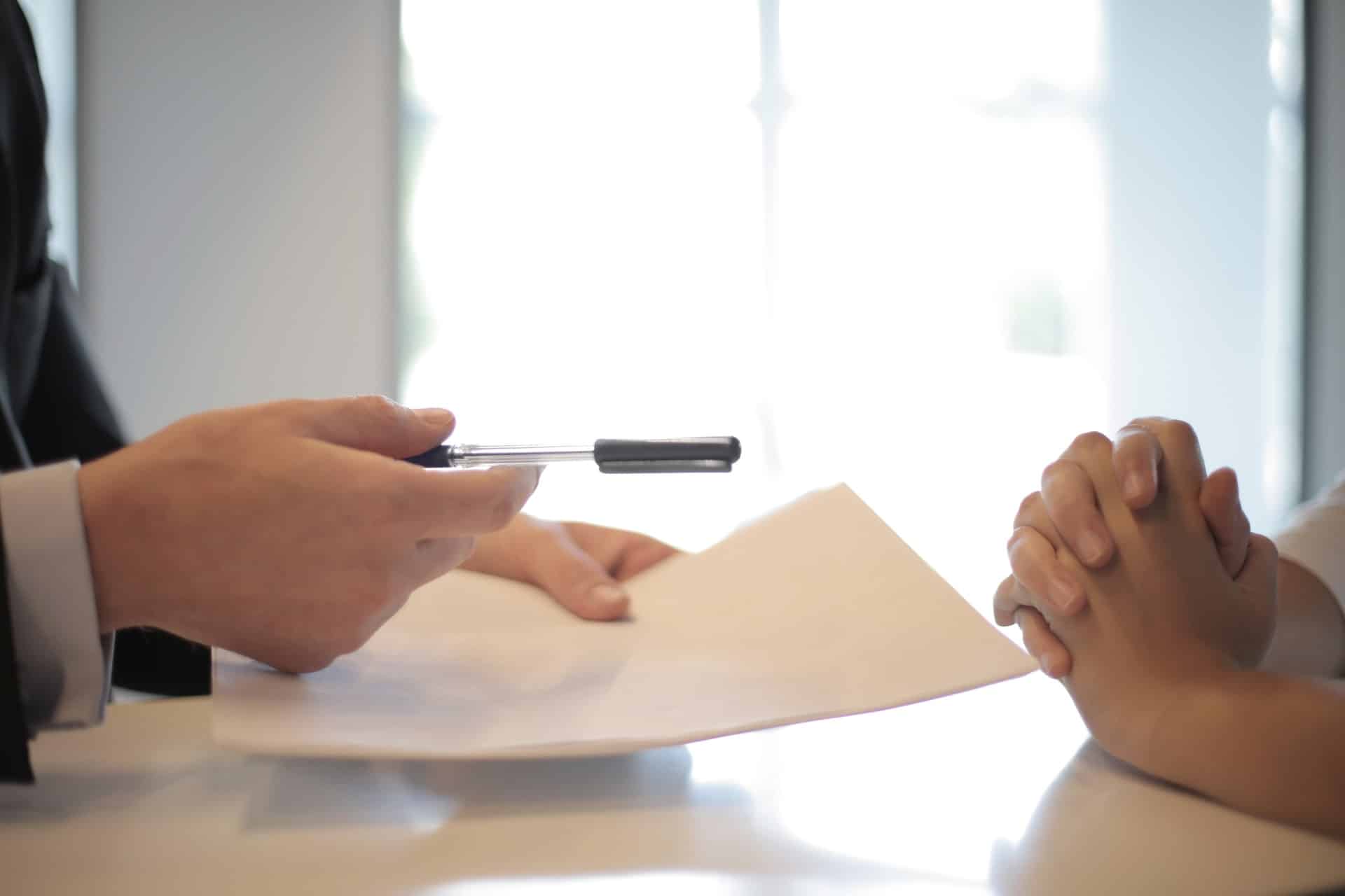 Person handing pen and paper