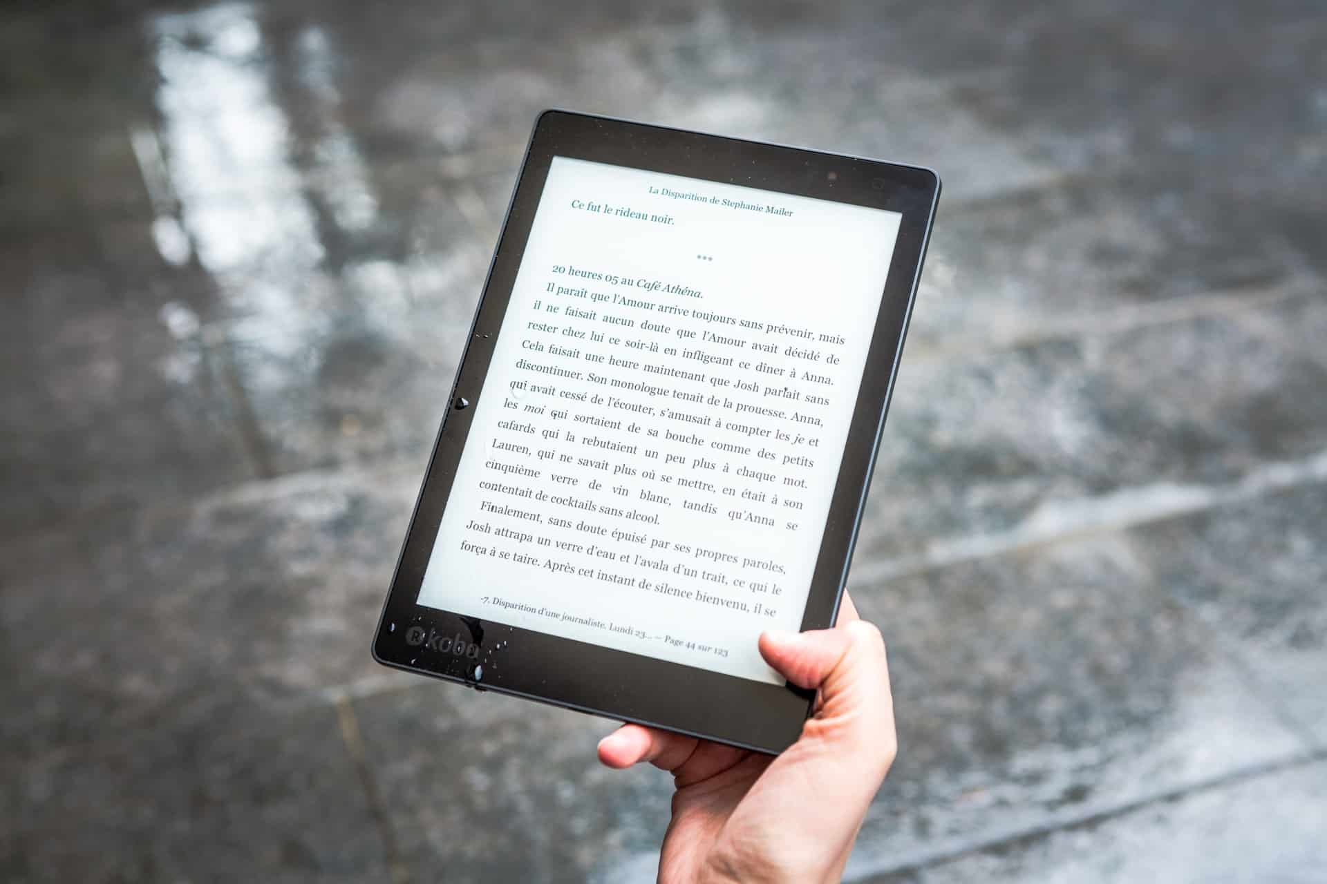 Person holding eBook in rain