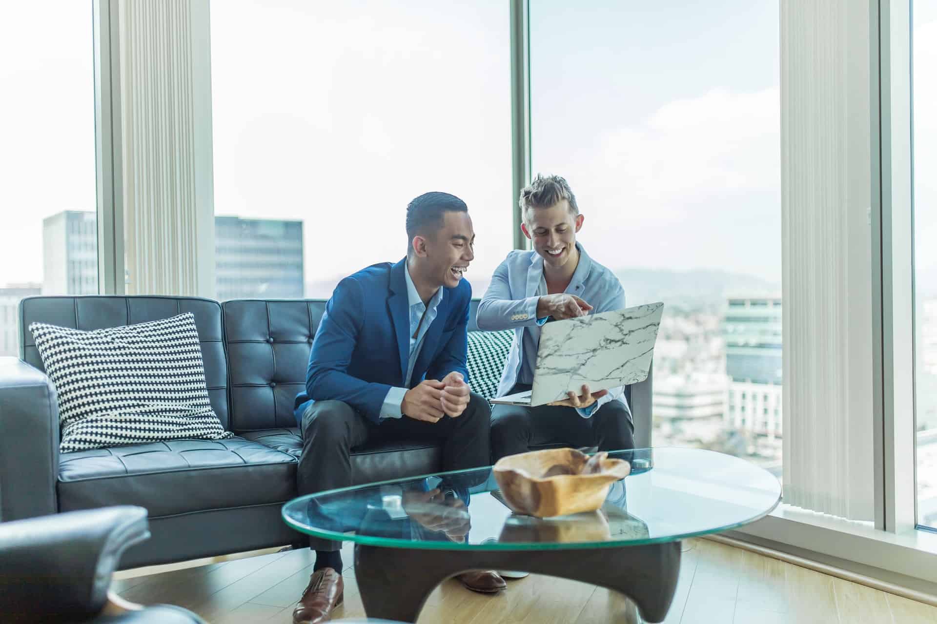 Two men smiling at laptop