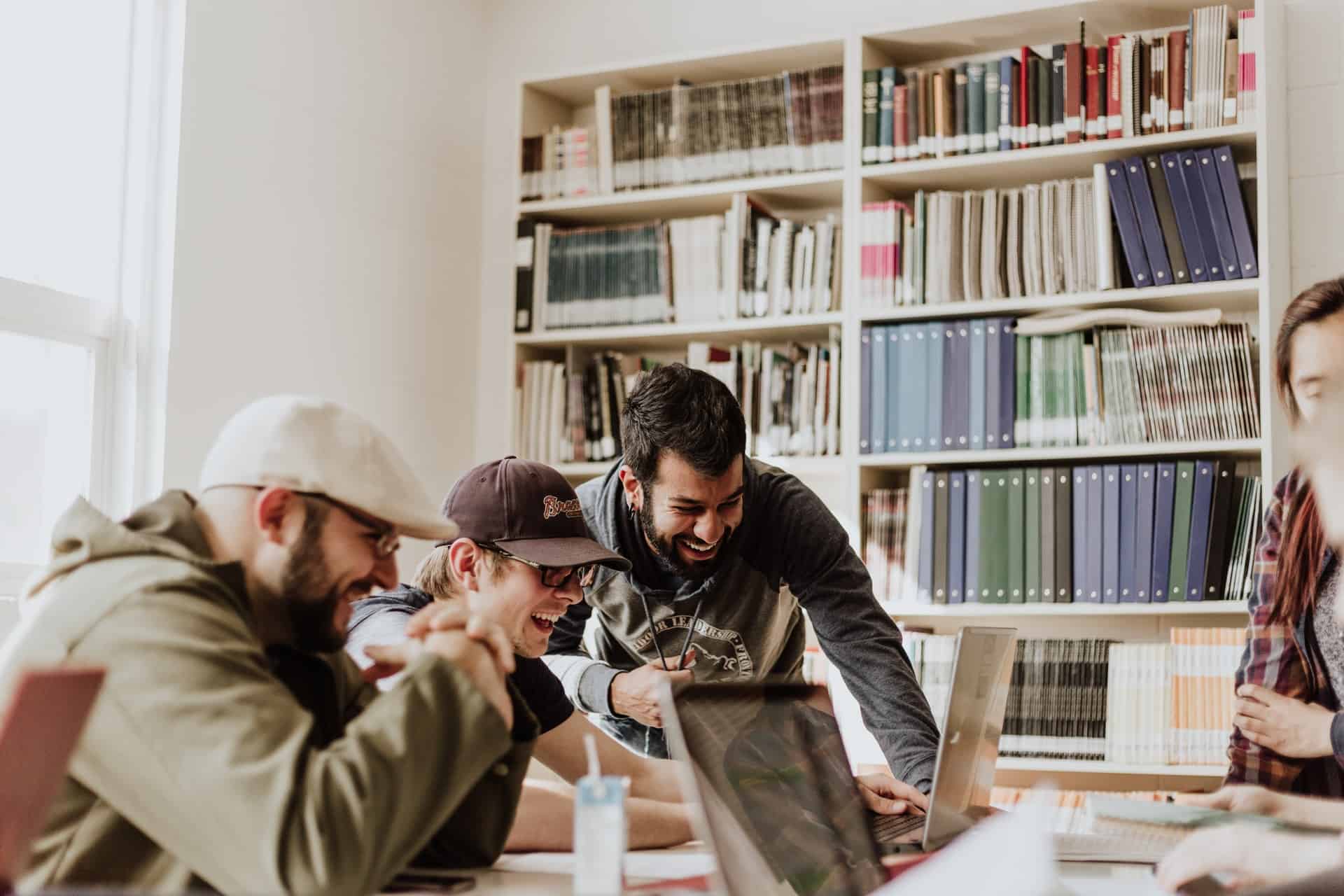 Three men laughing at computer