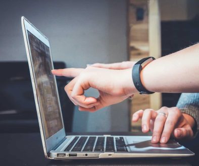 Person pointing to the laptop screen