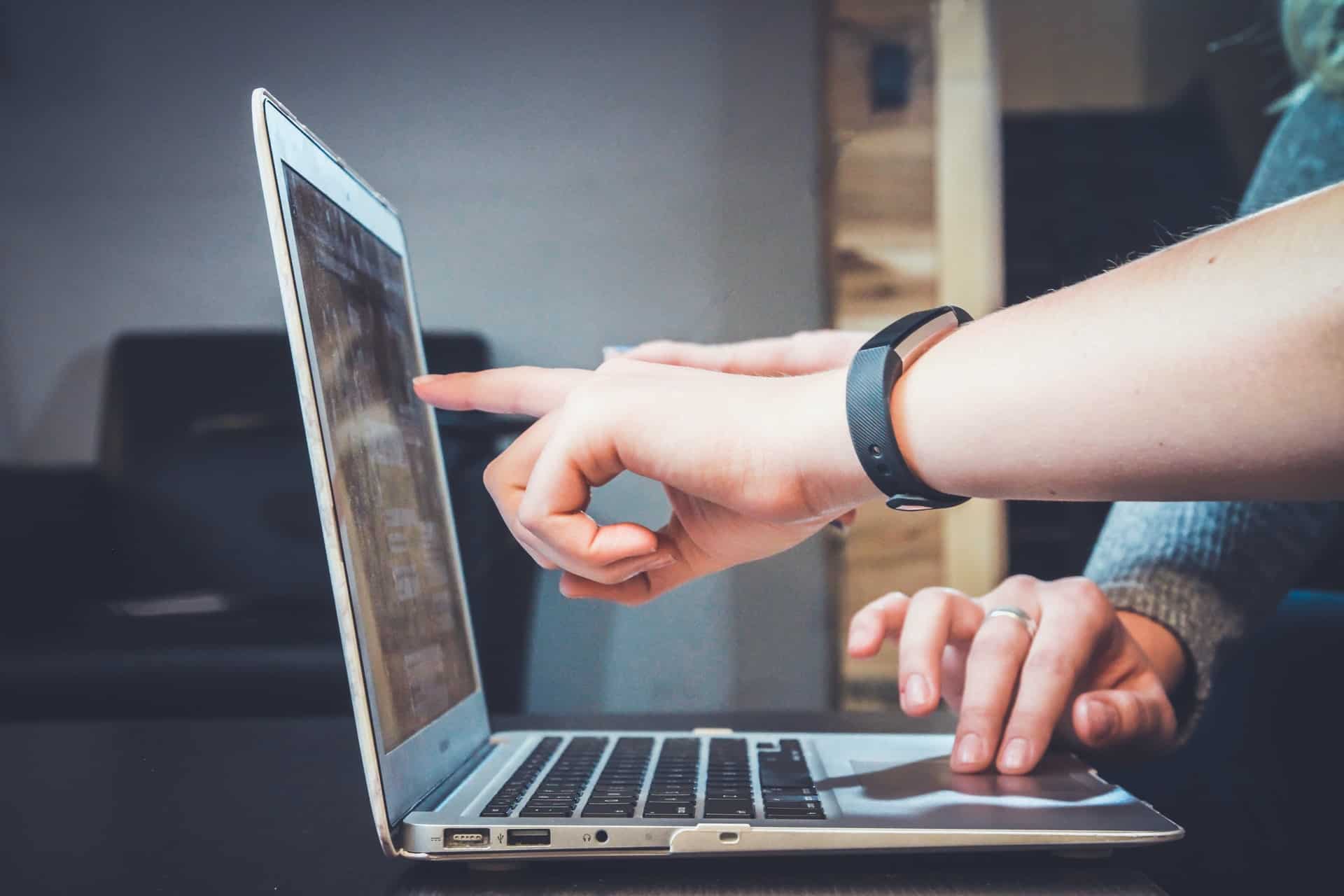 Person pointing to the laptop screen