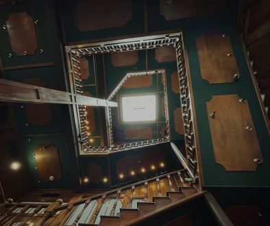 a room filled with lots of wooden furniture team solving puzzle, escape room clues, immersive set, gears, futuristic screen