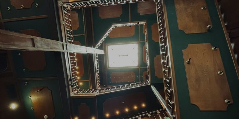 a room filled with lots of wooden furniture team solving puzzle, escape room clues, immersive set, gears, futuristic screen