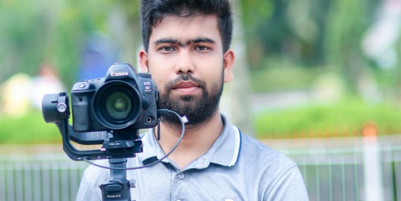 a man holding a camera iphone video editing, professional mobile editor, lumafusion