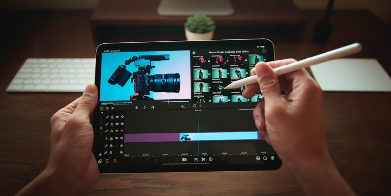 person holding black tablet computer iphone video editing, professional mobile editor, lumafusion