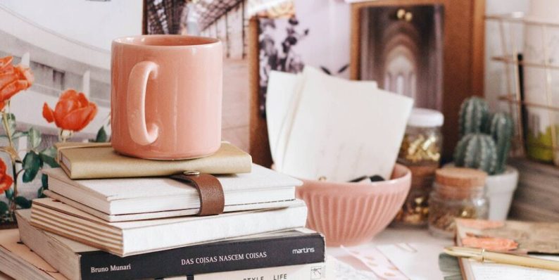 brown ceramic coffee mug on book hotel lobby, front desk, hospitality staff