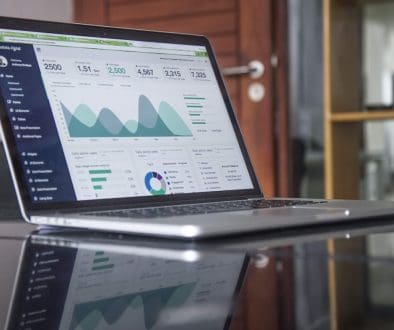 laptop computer on glass-top table ecommerce reports, conversion rate, data analytics