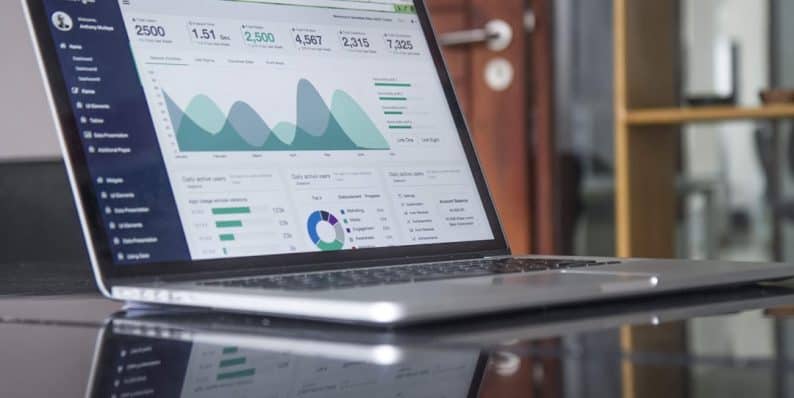 laptop computer on glass-top table ecommerce reports, conversion rate, data analytics