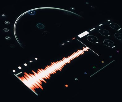 A close up of a remote control with a sound wave audacity interface, audio editing, user dashboard