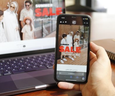 A person holding a cell phone in front of a laptop tiktok ecommerce, smartphone shopping, video marketing