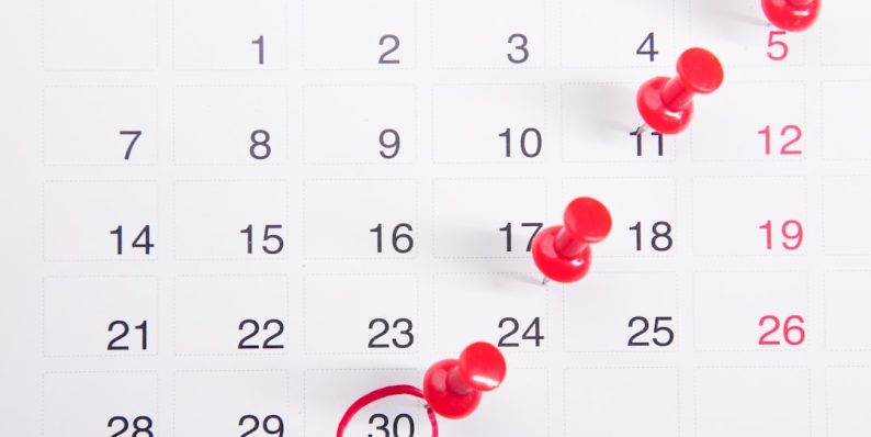 a calendar with red push buttons pinned to it iphone software update, ios new version, calendar bug fix