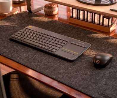 a computer keyboard and mouse on a desk brown leather sleeve office desk apple laptop