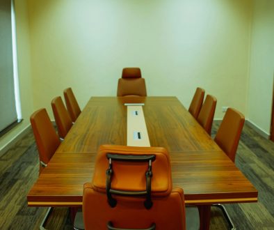 a conference table with a laptop on top of it meeting room, executives, technology tools