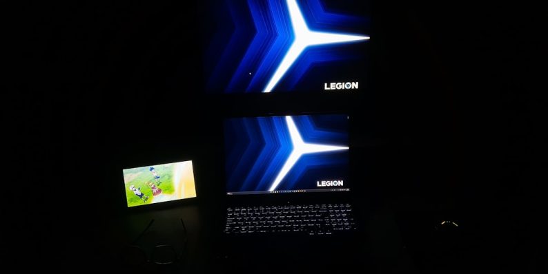 A laptop computer sitting on top of a desk acer swift x gaming setup, laptop with lights, gamer playing