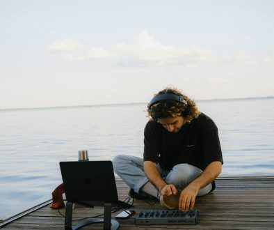 a man sitting on a dock working on a laptop business owner working on laptop, wordpress admin dashboard, cybersecurity lock icon