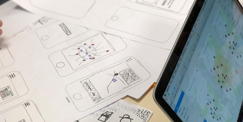 a person sitting at a table with a tablet canva app, logo editing, startup teamwork