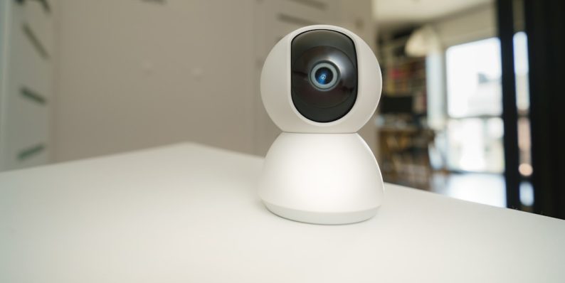 A small camera sitting on top of a white table windows camera, webcam app, pc camera tool