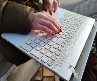 a woman is typing on a laptop outside business owner working on laptop, wordpress admin dashboard, cybersecurity lock icon