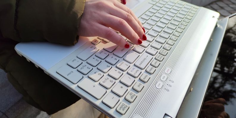 a woman is typing on a laptop outside business owner working on laptop, wordpress admin dashboard, cybersecurity lock icon