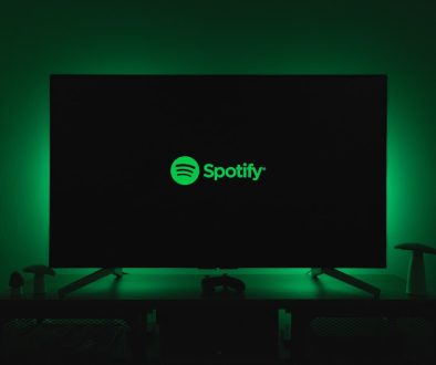 the spotify logo is lit up on a flat screen tv spotify free, music ads, listening limitations