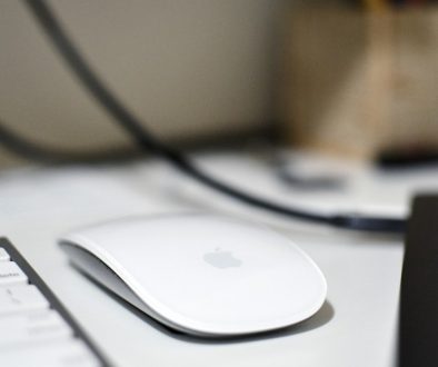 a computer mouse sitting on top of a white desk macbook mouse settings user interface, system preferences