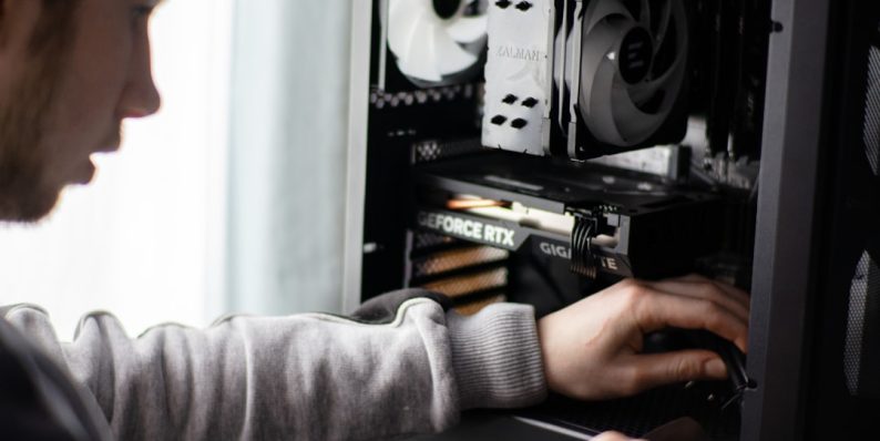 A man is working on a computer in a room computer maintenance, error prevention, antivirus update