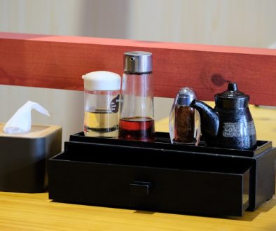 a wooden table topped with a black tray filled with different types of items pod coffee maker, kitchen counter, steaming coffee cup a wooden table topped with a black tray filled with different types of items pod coffee maker, kitchen counter, steaming coffee cup