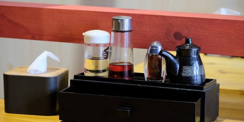 a wooden table topped with a black tray filled with different types of items pod coffee maker, kitchen counter, steaming coffee cup a wooden table topped with a black tray filled with different types of items pod coffee maker, kitchen counter, steaming coffee cup