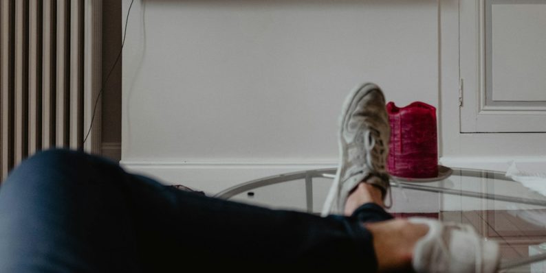 man lying on sofa infront of TV frustrated viewer popcorn couch netflix