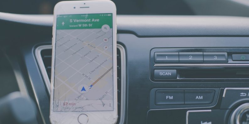 silver iPhone 6 on front of car aircon tracking apps, delivery management, smartphone dashboard
