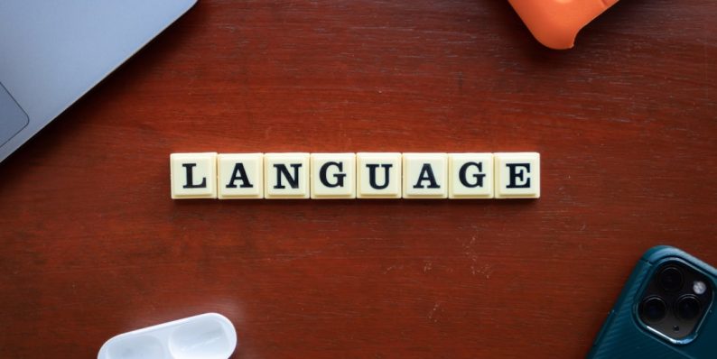the word language spelled with scrabble tiles on a table translation tools, bilingual people, language app