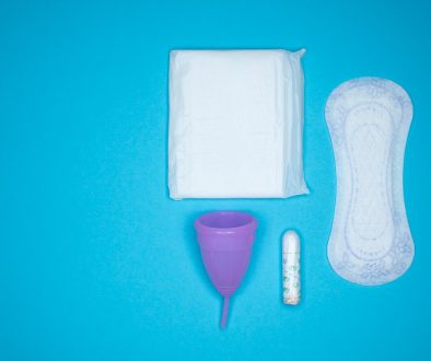 a blue table with a toothbrush, a tube of toothpaste and a sanitary pads packaging, menstrual hygiene, feminine care