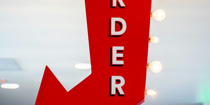 a red arrow sign hanging from a ceiling ecommerce order cancel, magento admin, cancel button