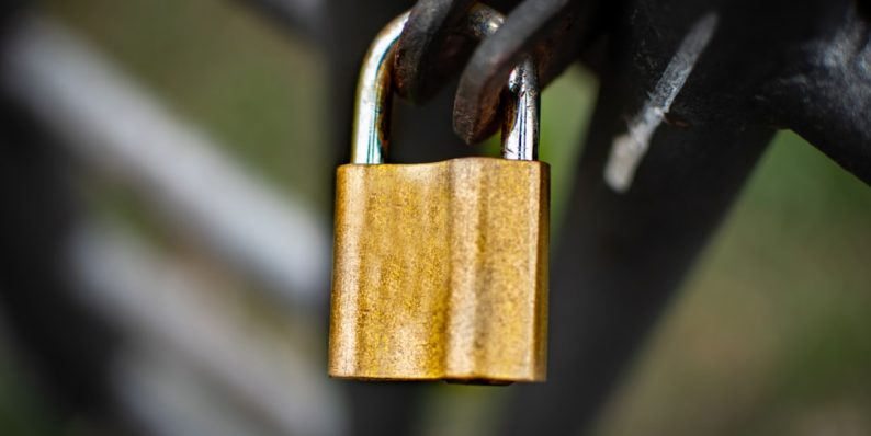 brown padlock on black metal fence team security vpn authentication enterprise