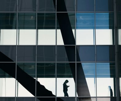 a man standing on a ledge in front of a tall building smart contract audit, defi compliance, onchain risk