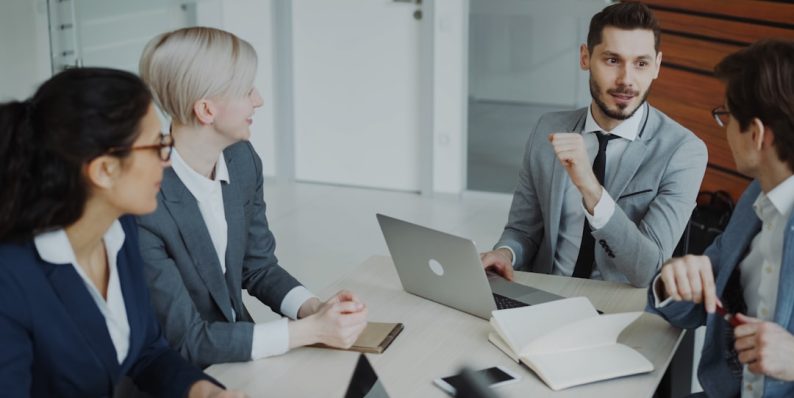 Four professionals in a business meeting around a table. communication teamwork office presentation
