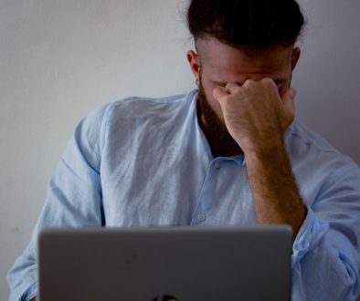 man in blue dress shirt holding silver macbook buffering video frustrated user wifi man in blue dress shirt holding silver macbook buffering video frustrated user wifi