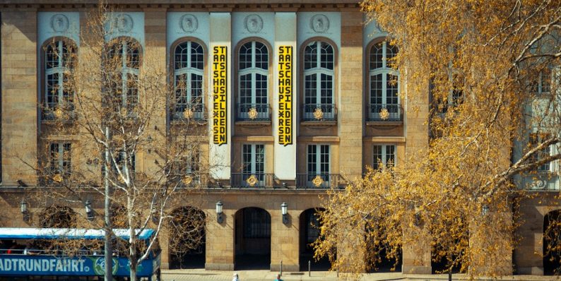 A gorgeous building with people walking around. university lecture, academic conference, politics