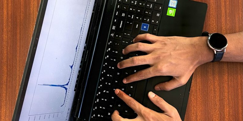 a person typing on a laptop on a wooden table newsletter analytics dashboard charts laptop screen