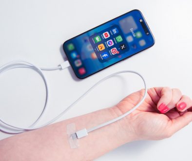a woman's arm holding a cell phone and a charger attached to it wearable devices, breathing technology, healthcare app a woman's arm holding a cell phone and a charger attached to it wearable devices, breathing technology, healthcare app