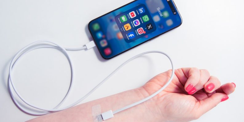a woman's arm holding a cell phone and a charger attached to it wearable devices, breathing technology, healthcare app