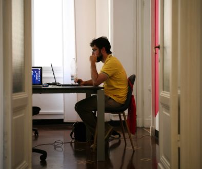 man siting facing laptop computer voice typing smartphone studying ai