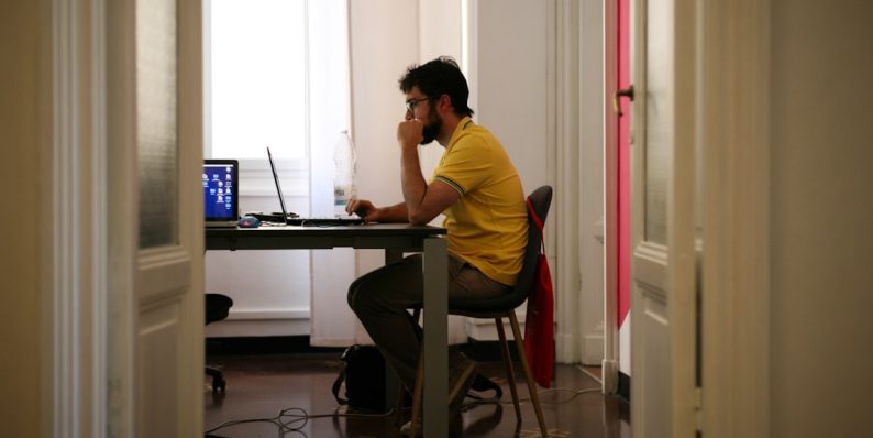 man siting facing laptop computer voice typing smartphone studying ai