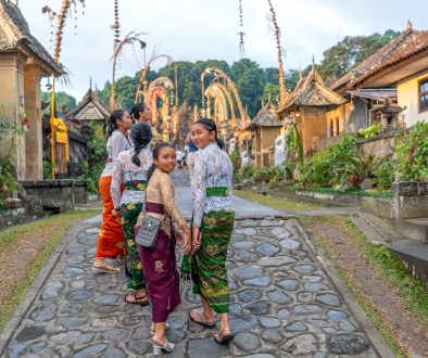 A group of people walking down a cobblestone road local guide storytelling, small group travel, cultural immersion, traditional village setting