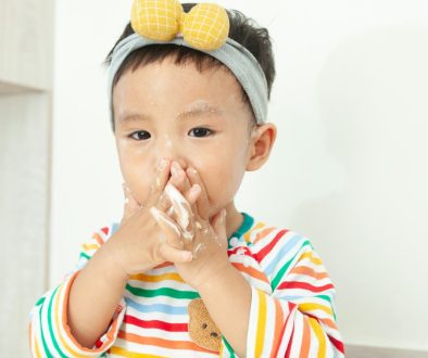 A little girl standing in a kitchen with a messy face child with nasal congestion, sore throat, adenoiditis